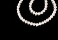 White pearls necklace on black background. Royalty Free Stock Photo