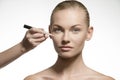 Natural woman applying cosmetics on her visage Royalty Free Stock Photo