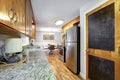 Natural wood cabinets in kitchen interior with island and black refrigerator Royalty Free Stock Photo