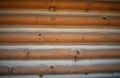 Natural wood texture background from stacked logs of a rustic cabin wall. Horizontal rough timber pattern creates cozy, warm, Royalty Free Stock Photo