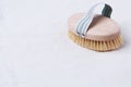 Natural wooden brush for dry body brushing on a beige organic cotton fabric
