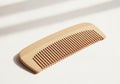 Natural wooden comb with soft sunlight shadows Royalty Free Stock Photo