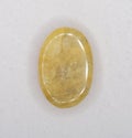 Natural yellow beryll oval cabochon on the white background Royalty Free Stock Photo