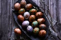 Naturally painted Easter eggs in a black clay plate on a rustic wooden background Royalty Free Stock Photo