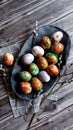Naturally painted Easter eggs in a black clay plate on a rustic wooden background Royalty Free Stock Photo