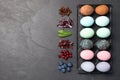 Naturally painted Easter eggs and space for text on black table, flat lay. Coffee beans, red cabbage, spinach, hibiscus, Royalty Free Stock Photo