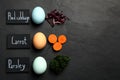 Naturally painted Easter eggs and space for text on black table, flat lay. Red cabbage, carrot, parsley used for coloring Royalty Free Stock Photo