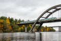 Nature autumn landscape scene with large arch concrete bridge with train crossing over calm water. Royalty Free Stock Photo