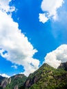 Nature background. Green tree, jungle on the beautiful shape mountain on blue sky and fluffy cloud with sunshine on sunny day. Royalty Free Stock Photo