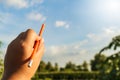 Pencil in left hand and blue sky Royalty Free Stock Photo