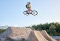 Nature, bike and cycling sports jump stunt on rocks ramp with fitness, training and exercise man. Athlete, bicycle and