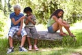 Nature, bullying and boys with girl in outdoor field, woods or forest laughing and teasing. Rude, upset and cruel young Royalty Free Stock Photo