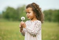 Nature, child and girl blowing a dandelion for a wish while playing, exploring or on an adventure. Calm, explore and Royalty Free Stock Photo