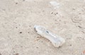 One plastic bottle as junk and garbage on the sand beach thrown in the water polluting the nature and environment view from above Royalty Free Stock Photo