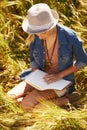 Nature field, book and woman reading diary entry about spring wellness, stress relief or creative story in countryside