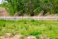 Nature field with White wood fence and green plants