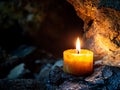 Nature and fire concept, A burning candle in a cave Royalty Free Stock Photo