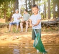 Nature, fishing and child with net in river, fun and happy time on camping holiday weekend in woods. Lake, forest and Royalty Free Stock Photo