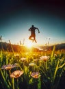 nature flowers at sunset man silhouette jumping with joy Royalty Free Stock Photo