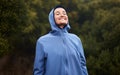 Nature, happiness and woman with raincoat, smile and wellness standing in outdoor park. Peace, calm and girl enjoying Royalty Free Stock Photo