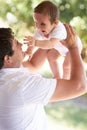 Nature, happy and father playing with baby for care, outdoor games and enjoy fun bonding time together in family park Royalty Free Stock Photo