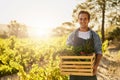 Nature has rewards for those who treat her well. a young man holding a crate full of freshly picked produce on a farm.