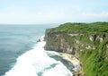 The nature high cliff with green plant reach to deep blue sea and surf on the coast.