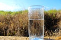 Nature in Israel. Cold mineral water in a glass against the background of a beautiful field and blue sky Royalty Free Stock Photo