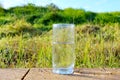 Nature in Israel. Cold mineral water in a glass against the background of a beautiful field and blue sky. Raindrops and Dew Drops Royalty Free Stock Photo