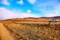 Nature landscape with car, golden grass, yellow hills and blue sky on background. Concept of world beautiful travel by Royalty Free Stock Photo