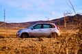 Nature landscape with car, golden grass, yellow hills and blue sky on background. Concept of world beautiful travel by Royalty Free Stock Photo