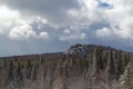 Nature landscape. Cumulus fluffy clouds looming over the spruce winter forest