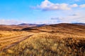 Nature landscape with golden glass, old rural road, hills and blue sky with white clouds on background in a nice day or Royalty Free Stock Photo