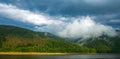 Nature landscape of green coniferous mountains above the lake on background of stormy gray clouds, rainy weather, Ukraine, Royalty Free Stock Photo