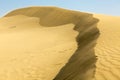 Sand dunes with wind in the desert with blue sky Royalty Free Stock Photo