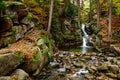 Nature landscape. Waterfall. Beautiful fall mountain wild Forest waterfall with green moss cover stones. Forest autumn landscape