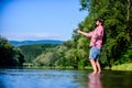 Nature lover. hipster fishing with spoon-bait. successful fisherman in lake water. fly fish hobby. Summer fishery Royalty Free Stock Photo