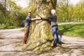 Nature loving young couple hugging tree trunk Royalty Free Stock Photo