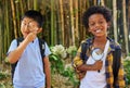 Nature, magnifying glass and portrait of curious children exploring in park for education in sustainability and science