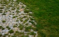 Nature paths in the park made of fine rolled trowel. irregular stone paving is overgrown with individual tufts of grass. it gives Royalty Free Stock Photo