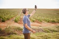 Nature, phone and a man with lost signal in field on farm road trip. Travel, view and vineyard, young traveler with