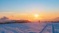 Nature photographer on a snowy field at sunset time Royalty Free Stock Photo