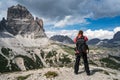 Nature photographer tourist with camera shoots while standing Italy Dolomites Alps