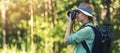 Nature photography - woman photographer taking picture with analog film camera in forest. banner copy space