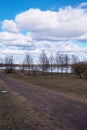 Nature picture in early spring by the lake with trees and cloudy sky