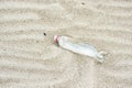 One plastic bottle as junk and garbage on the sand beach thrown in the water polluting the nature and environment view from above Royalty Free Stock Photo