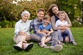 Nature, portrait and children with parents and grandmother relaxing on grass in outdoor park or garden. Smile, family Royalty Free Stock Photo