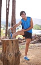 Nature, portrait or runner stretching legs for fitness training, wellness or exercise outdoors on tree log. Man Royalty Free Stock Photo