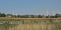 Nature reserve of Rieme, with industrial chimney and wind turbines and church tower in the distance