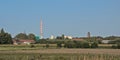 Nature reserve of Rieme, with industrial chimney and wind turbines and church tower in the distance